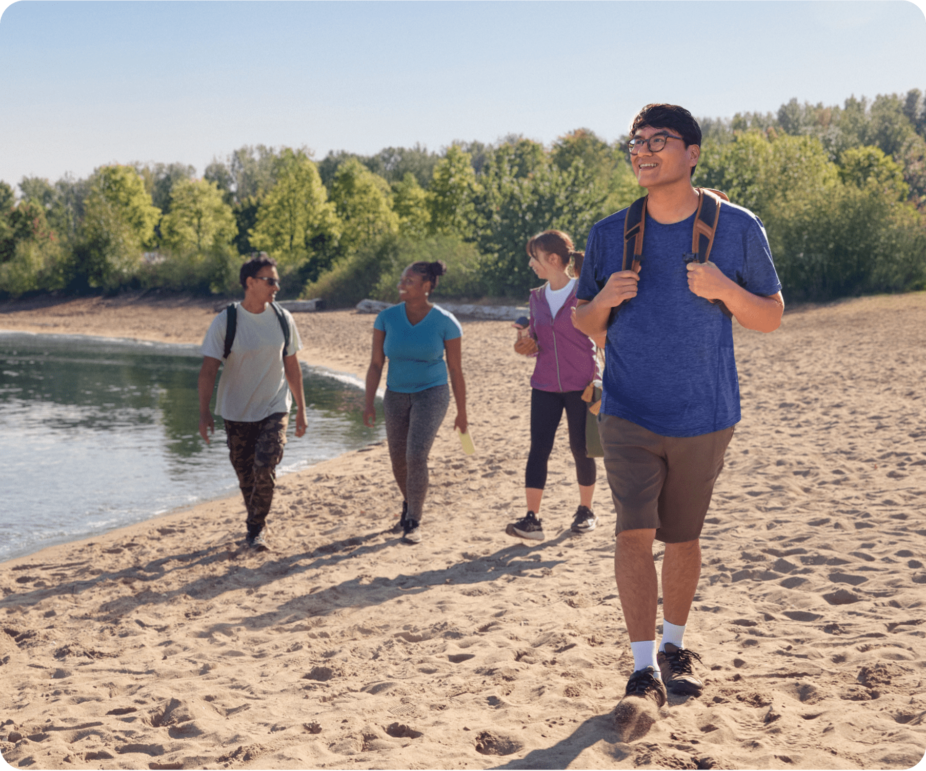 Four friends are walking along the beachfront.